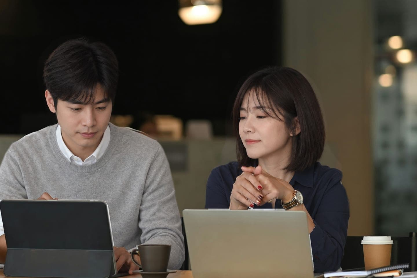 노트북 두 대를 앞에 두고 나란히 앉아 한 사람의 화면을 함께 들여다보는 상담 장면